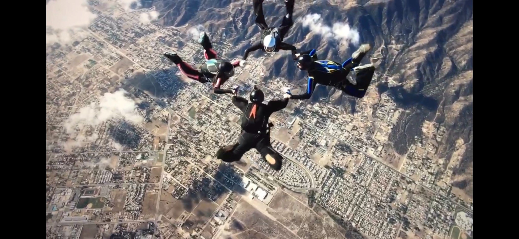 Skydivers flying together above the earth